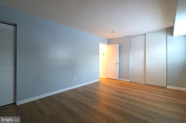 a view of an empty room with wooden floor