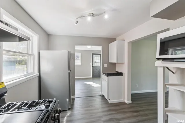 a kitchen with a refrigerator and a stove top oven