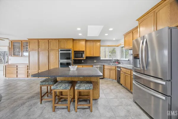 a kitchen with stainless steel appliances granite countertop a sink a stove and cabinets