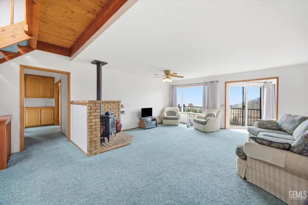 a kitchen with kitchen island granite countertop wooden cabinets a counter top space stainless steel appliances and a large window