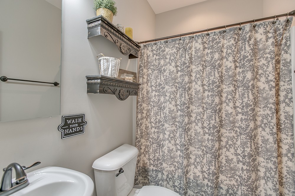 9630 Mona Road Murfreesboro, TN 37129 - Photo 19 of 39 a bathroom with a toilet and a shower curtain