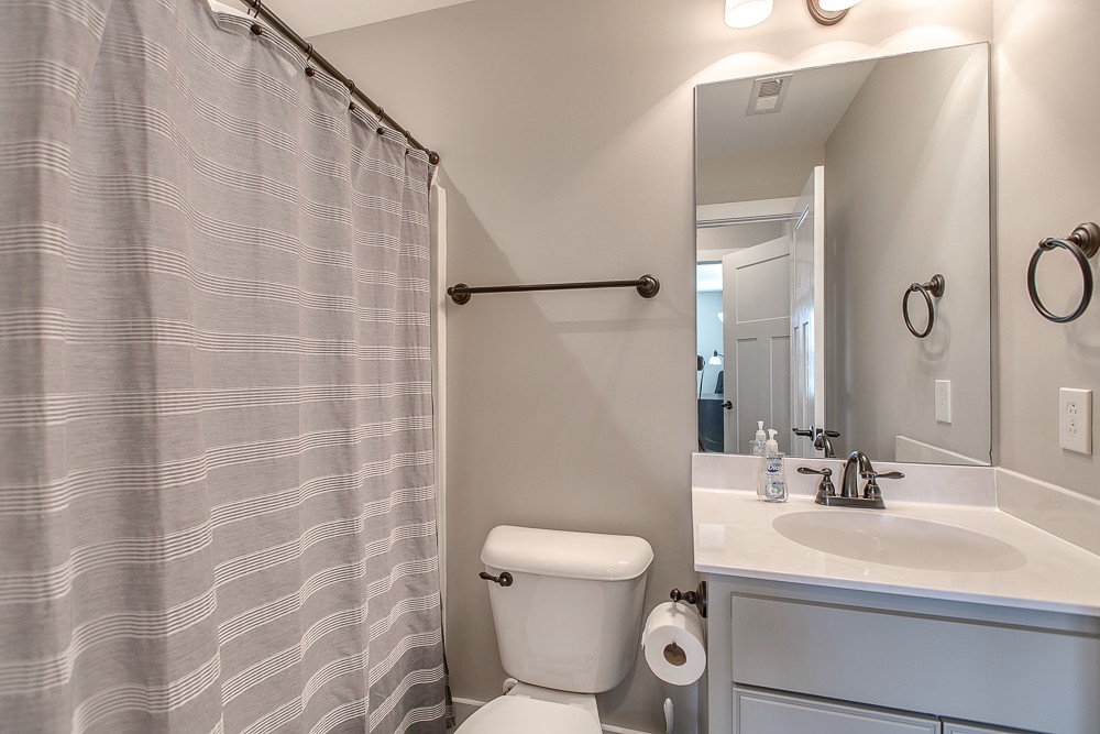 9630 Mona Road Murfreesboro, TN 37129 - Photo 30 of 39 a bathroom with a sink a toilet a mirror and shower curtain