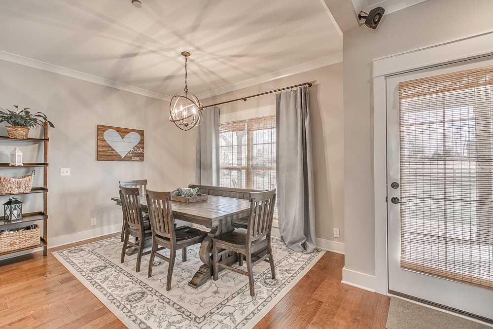 9630 Mona Road Murfreesboro, TN 37129 - Photo 10 of 39 a dining room with wooden floor a chandelier a wooden table and chairs