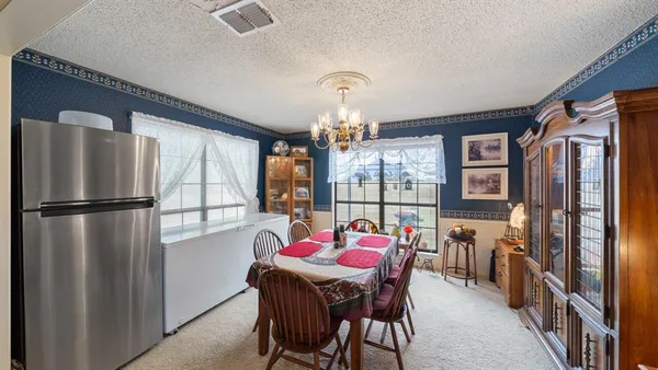 a dining room with furniture a chandelier and window