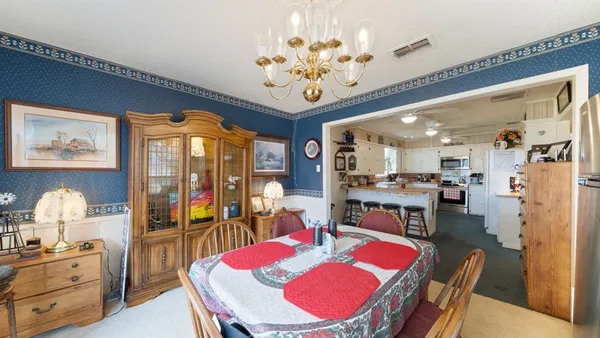a view of a dining room with furniture a chandelier and wooden floor