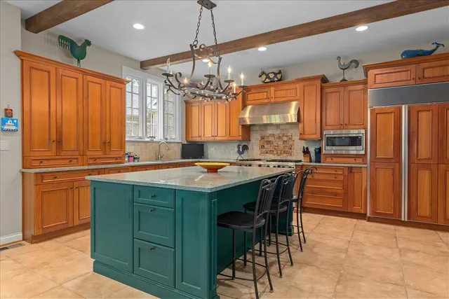 a kitchen with kitchen island granite countertop wooden cabinets and a refrigerator