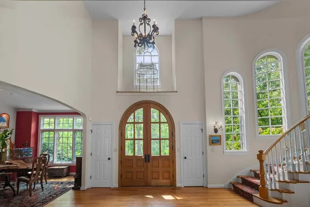 a view of an entryway with wooden floor windows and a livingroom