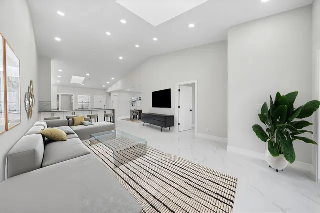 a living room with furniture potted plant and a flat screen tv