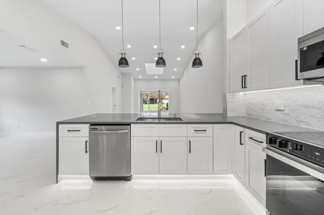 a kitchen with granite countertop cabinets stainless steel appliances and a fireplace