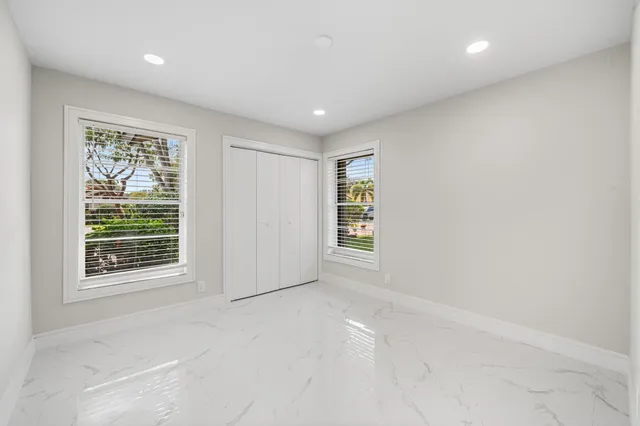 a bathroom with a granite countertop sink a toilet a mirror and shower