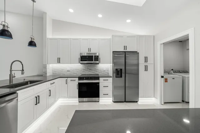 a kitchen with stainless steel appliances granite countertop a refrigerator and a sink