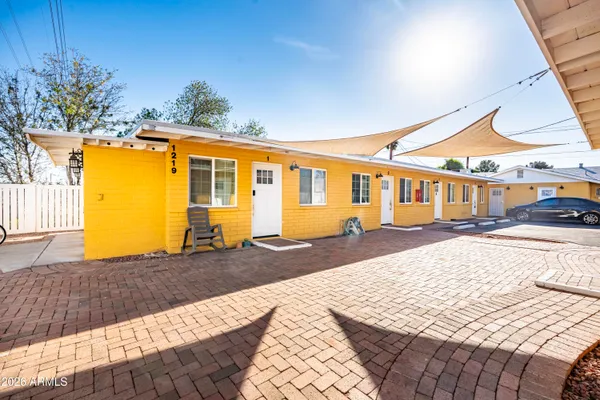 a bedroom with a bed dresser and a large window