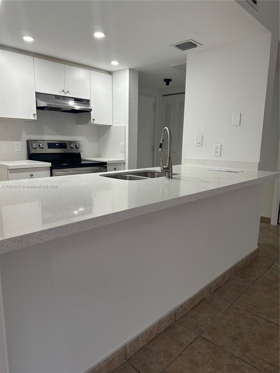 8100 Geneva Court, Unit 142 Doral, FL 33166 - Photo 4 of 11 a kitchen with stainless steel appliances a sink stove and cabinets