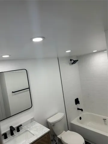 an empty room with chandelier fan and windows