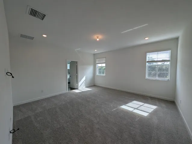 an empty room with windows and closet