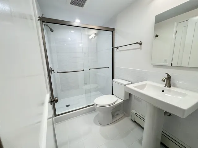 a bathroom with a sink toilet and shower