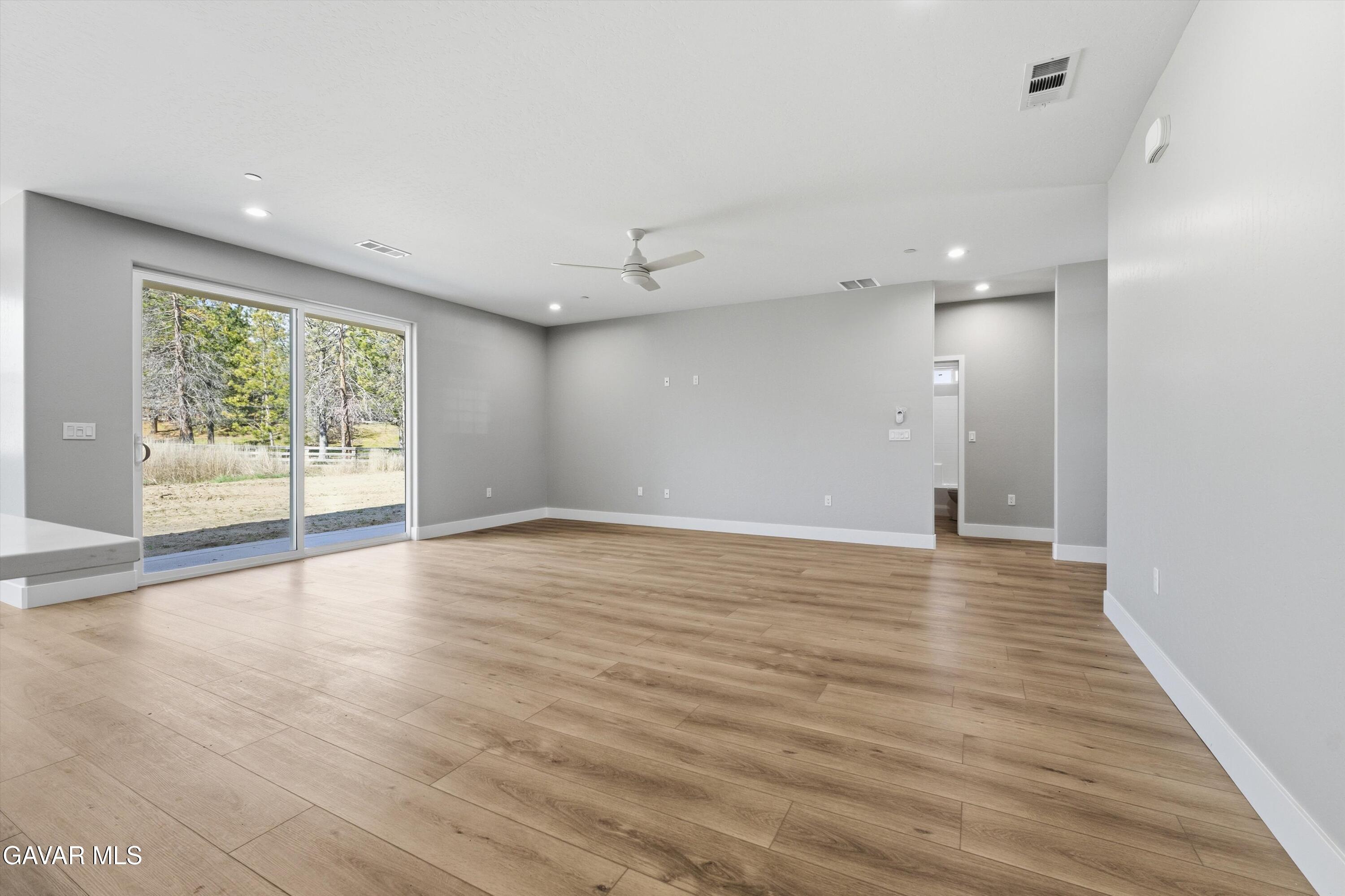 22613 Royal Place Tehachapi, CA 93561 - Photo 4 of 28 an empty room with wooden floor and windows