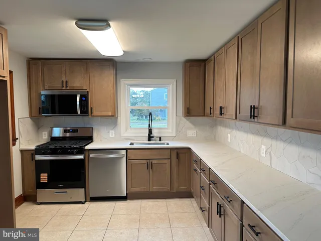 a kitchen with a sink stove top oven and cabinets