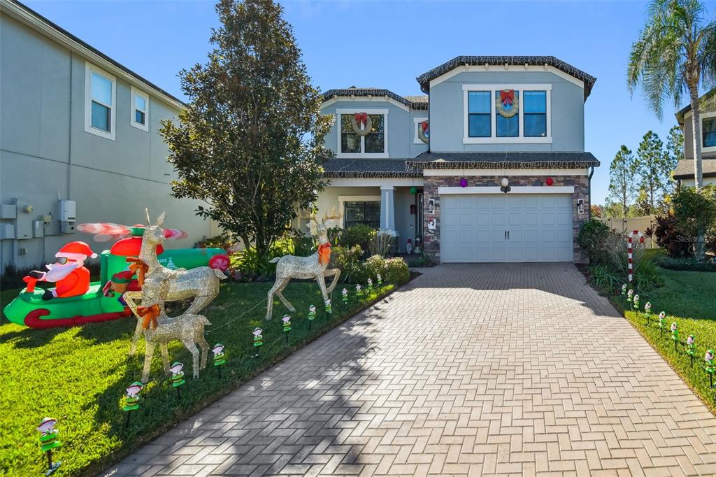a front view of house and yard with beautiful flowers and green space