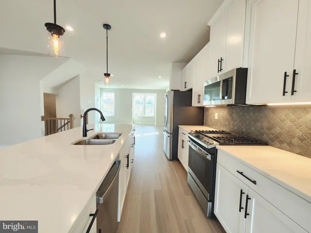 a kitchen with stainless steel appliances granite countertop a sink a stove and a refrigerator