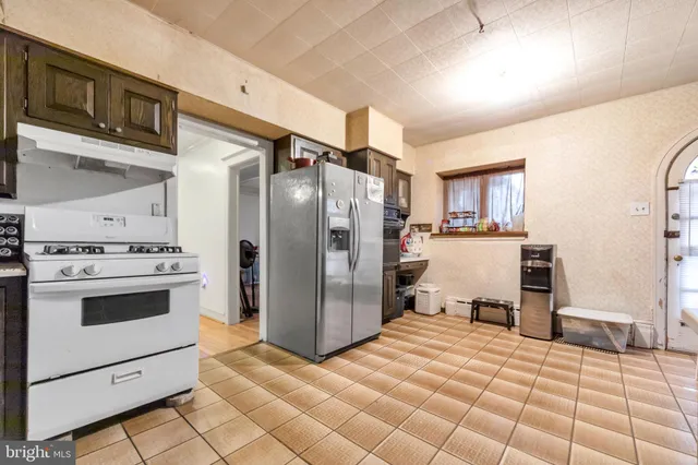 a kitchen with a stove a refrigerator and cabinets