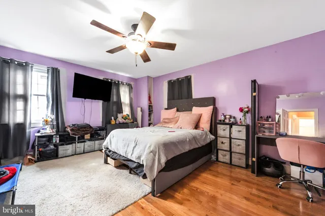 a bedroom with a bed a dresser and chair