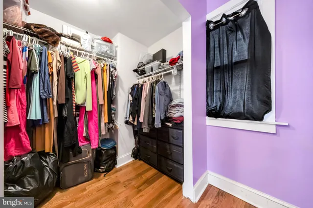 a view of walk in closet with clothes and shoes