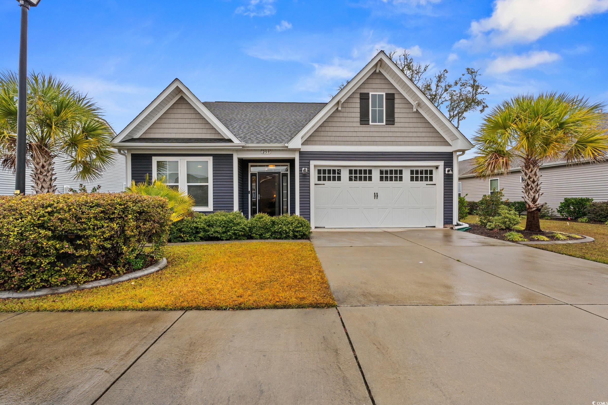 View of front of home featuring concrete driveway, a garage, and a shingled roof