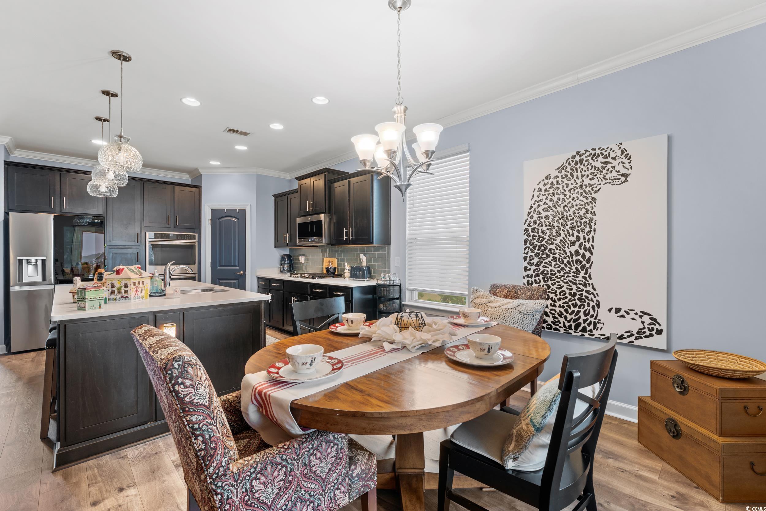 259 Switchgrass Loop Little River, SC 29566 - Photo 10 of 31 Dining space with ornamental molding, a chandelier, recessed lighting, and light wood-style flooring