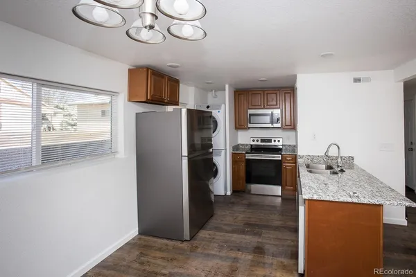 a kitchen with stainless steel appliances granite countertop a refrigerator a stove a sink and a microwave