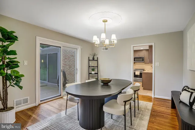 a dining room with furniture a large window and a potted plant