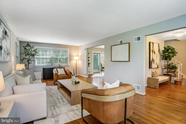 a kitchen with kitchen island granite countertop wooden cabinets a stove a refrigerator a sink a dining table and chairs