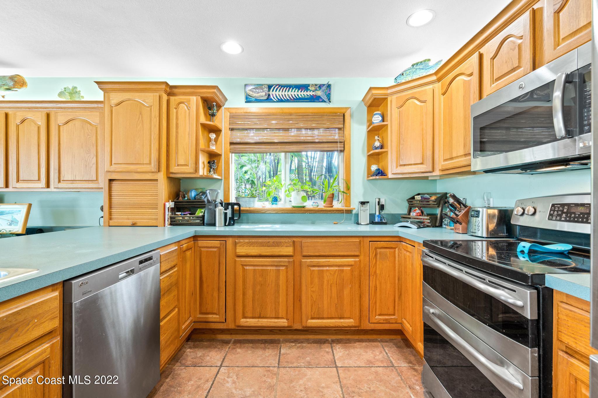14 Country Club Road Cocoa Beach, FL 32931 - Photo 17 of 64 a kitchen with stainless steel appliances granite countertop a sink and cabinets