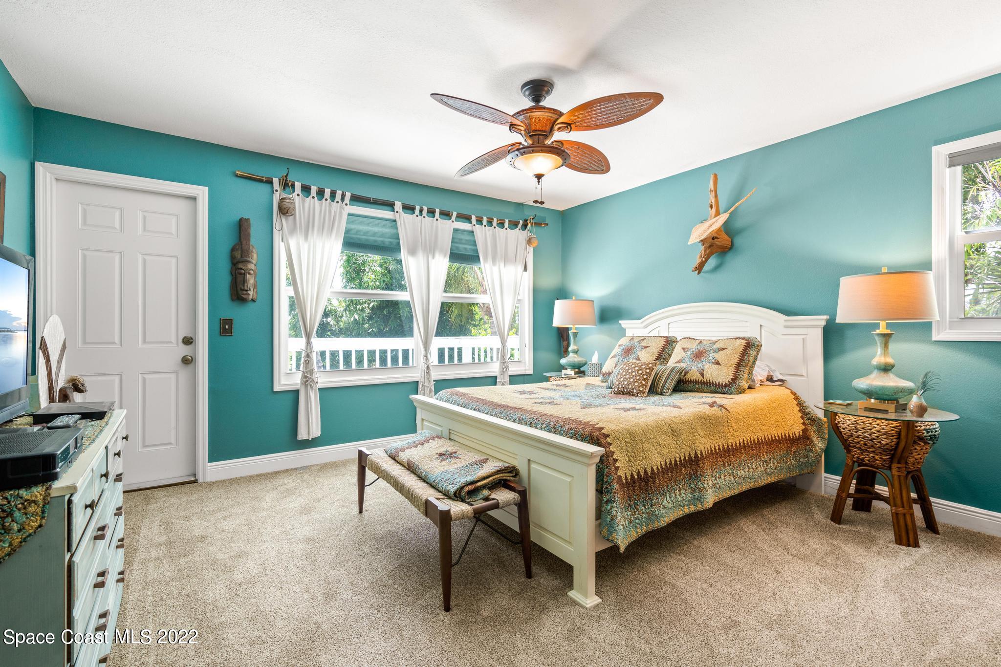 14 Country Club Road Cocoa Beach, FL 32931 - Photo 29 of 64 a bedroom with a bed and a chandelier