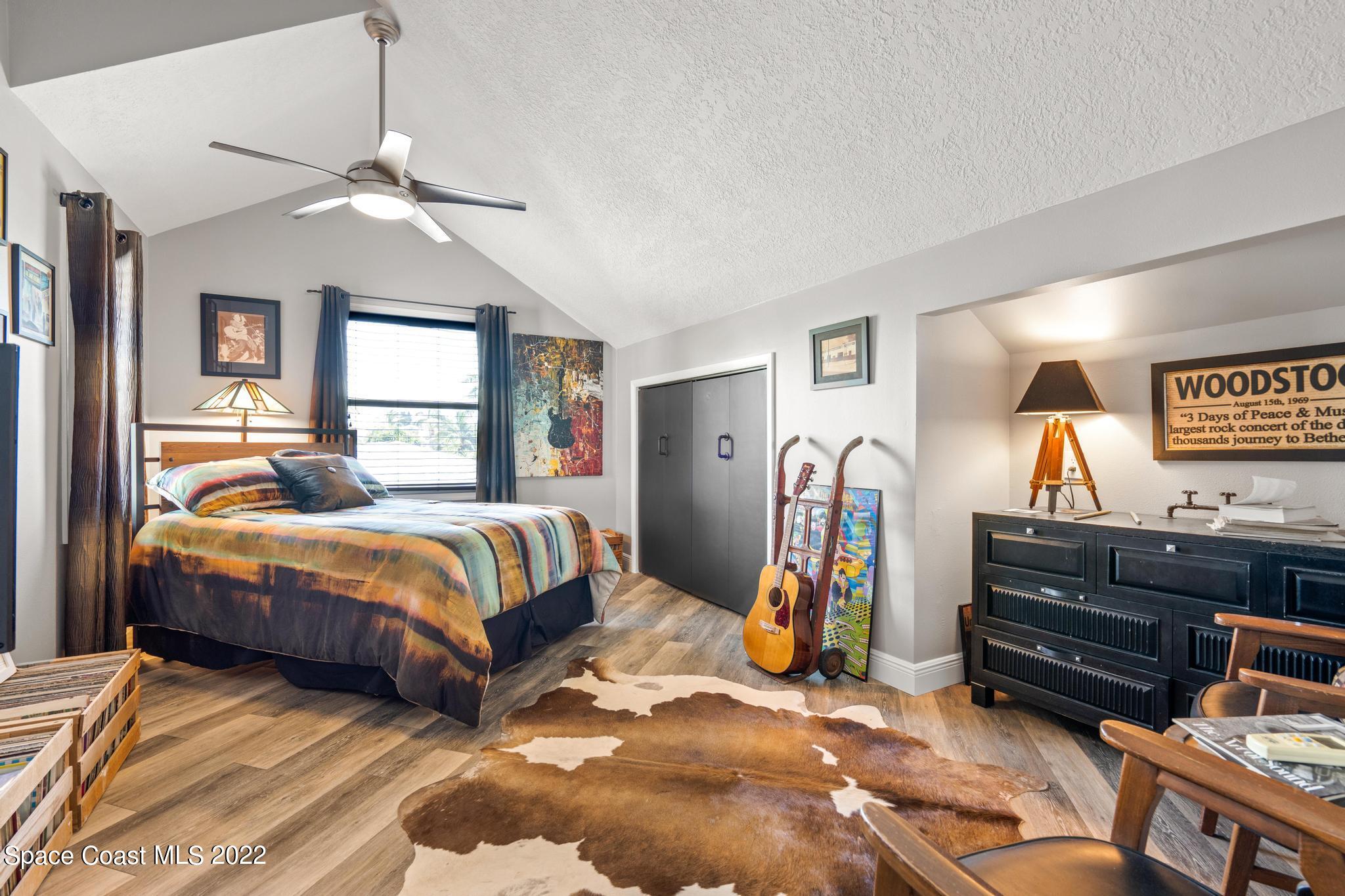 14 Country Club Road Cocoa Beach, FL 32931 - Photo 33 of 64 a bedroom with a bed and a chandelier