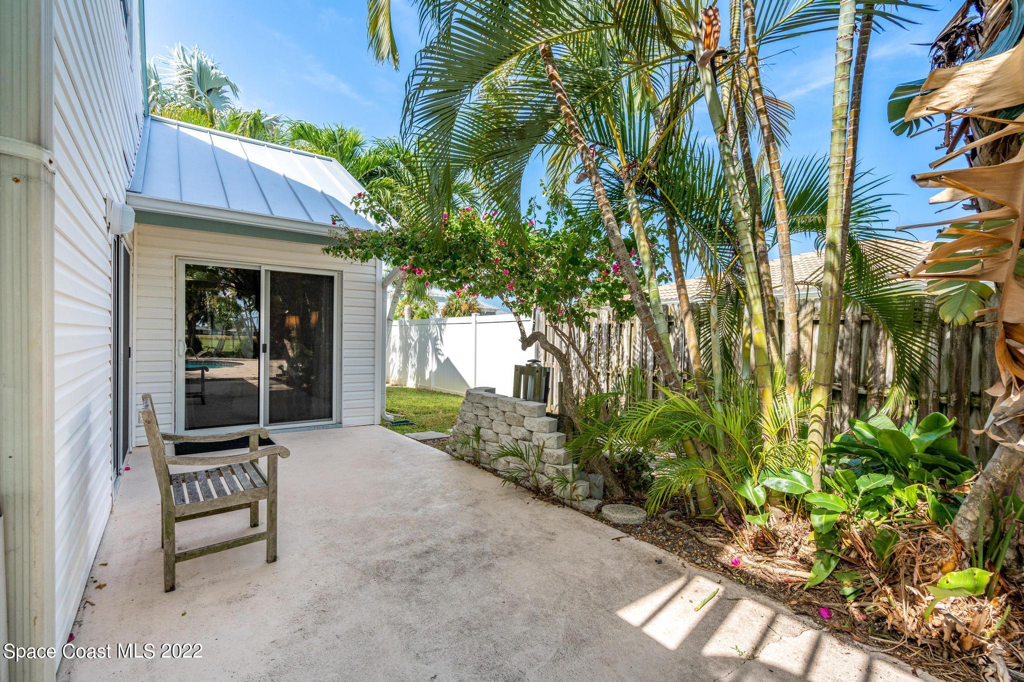 14 Country Club Road Cocoa Beach, FL 32931 - Photo 54 of 64 a backyard of a house with table and chairs and potted plants