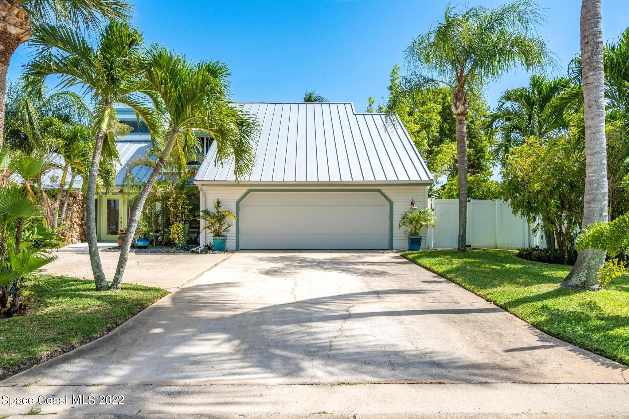 14 Country Club Road Cocoa Beach, FL 32931 - Photo 56 of 64 a front view of a house with a yard and garage