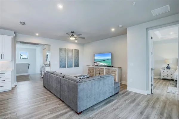 a kitchen with stainless steel appliances kitchen island granite countertop a refrigerator a stove a sink dishwasher and a dining table with wooden floor