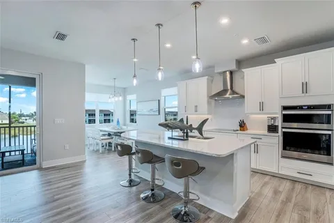a dining room with furniture a chandelier and wooden floor