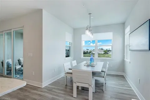 a dining room with furniture a chandelier and wooden floor