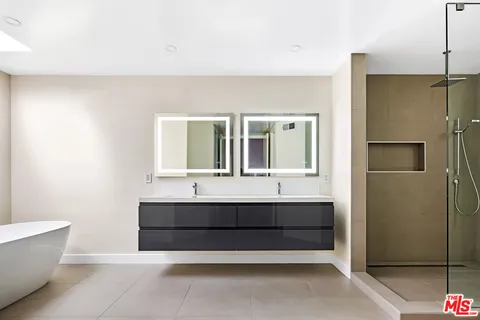 a bathroom with a double vanity sink mirror and shower