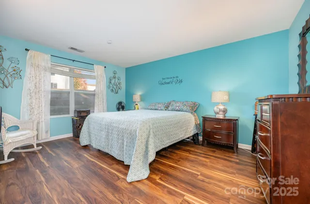 a bedroom with a bed and wooden floor