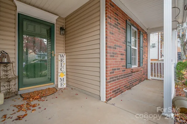 a view of a door and chair in front of house