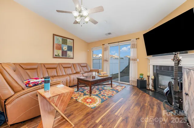 a living room with furniture a flat screen tv and a fireplace