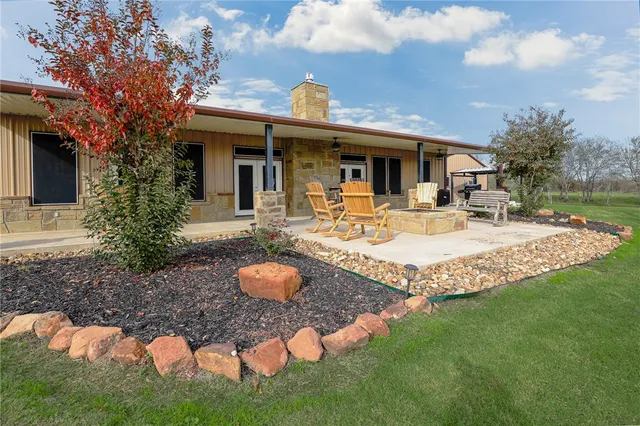 a view of a house with backyard and sitting area