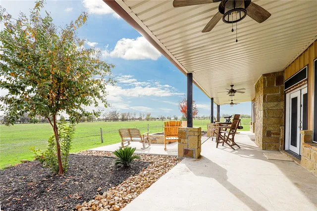 a view of a patio with table and chairs under an umbrella