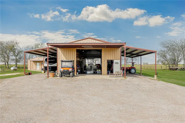 a view of a house with a yard and large tree