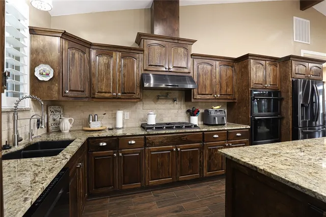 a kitchen with stainless steel appliances granite countertop a sink stove and refrigerator