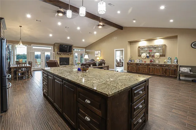 a kitchen with stainless steel appliances granite countertop plenty wooden cabinets counter space a sink and wooden floor