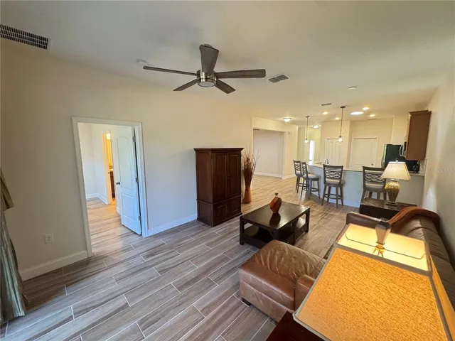 a living room with furniture and a wooden floor